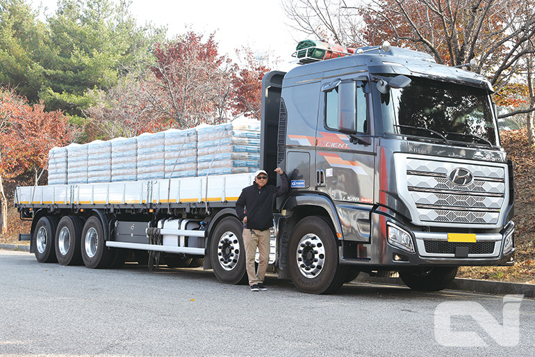 중량물 수송 경력만 20년 가까이 된 김상훈 사장(61)의 엑시언트 대형트럭에 장착된 브리지스톤 타이어 앞에서 포즈를 취하고 있다. 