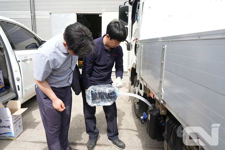 순회점검 서비스 캠페인에 방문한 고객 트럭에 요소수를 무상으로 주입해주고 있다.