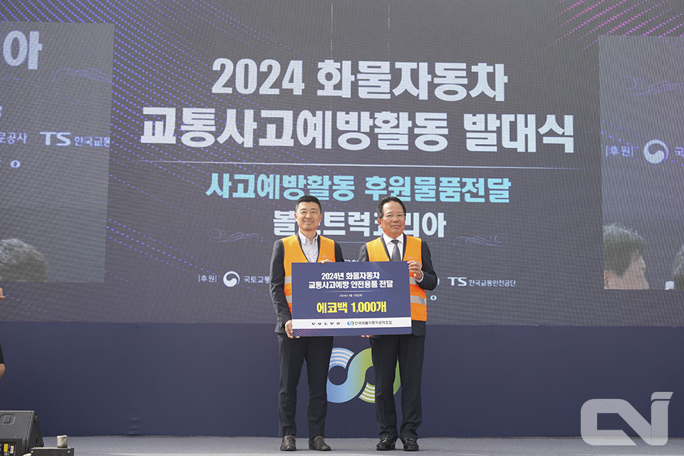 이현철 볼보트럭코리아 상무(왼쪽)가 최광식 회장에게 에코백을 전달하고 있다.