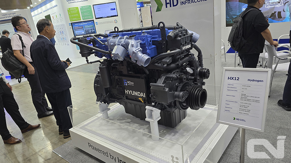 HD현대인프라코어에서 개발한 수소엔진 HX12를 관심 있게 보고 있는 일본 기업인들.