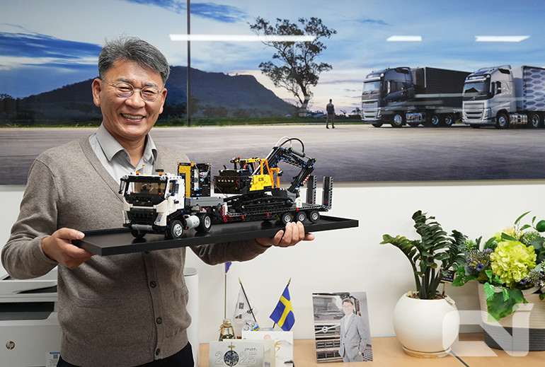 박강석 볼보트럭코리아 사장이 볼보트럭코리아와 볼보건설기계코리아 전직원이 참여해 조립한 레고블록. ​​​​​​​(로우베드 트레일러에 실린 볼보 굴삭기와 이를 견인하는 볼보 트랙터가 조화를 이룬다)