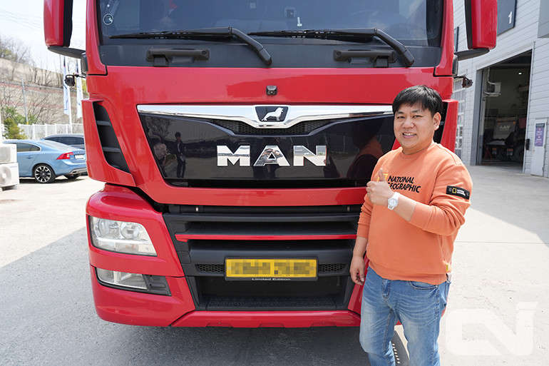 만 카고트럭 앞에서 포즈를 취하고 있는 이영규 사장