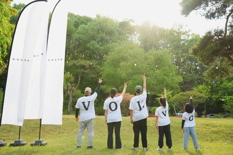 볼보 브랜드 가족들이 볼보트럭의 첫 글자인 'V'를 오른손으로 표현하고 있다.