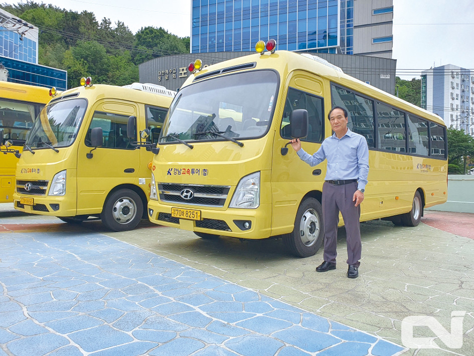 박숙현 부산 강남투어협동조합 대표이사가 현대 카운티 오토 차량의 옆에 서서 포즈를 취하고 있다.