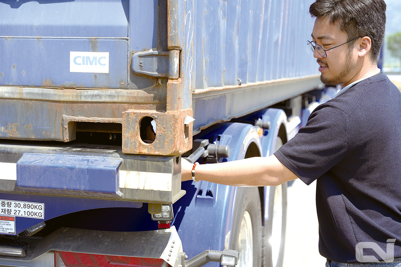 운행 전 트랙터에 컨테이너가 잘 체결되었는지, 꼼꼼히 확인하고 운행하는 김민우 사장.