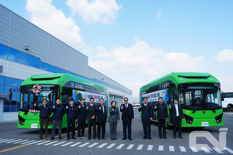우진산전의 임직원들이 한 자리에 모여 국내 최초 출시된 전장 9m급 수소전기버스 '아폴로 900 H2'의 출고를 기념하고 있다.